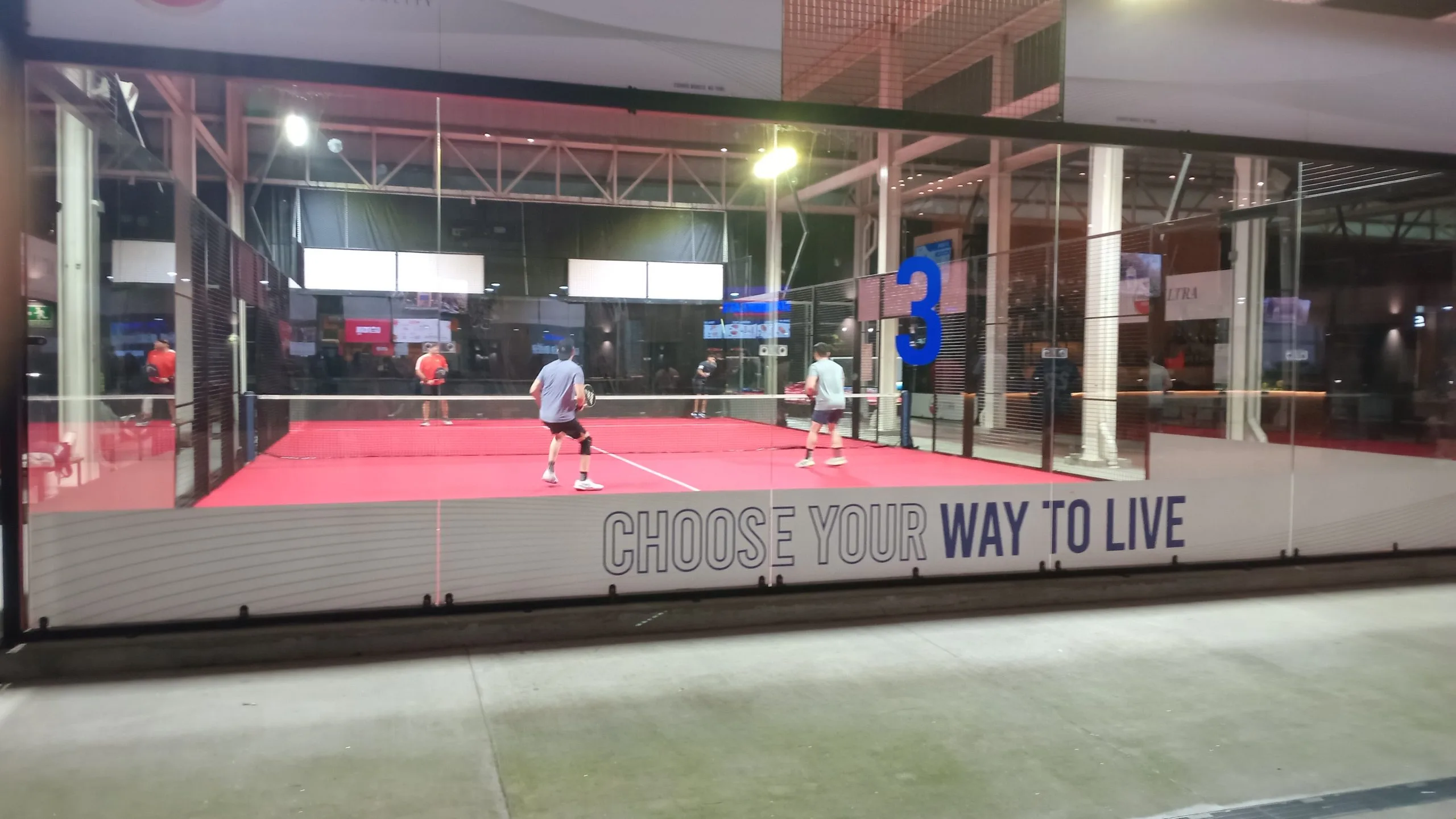Four players during a padel doubles match