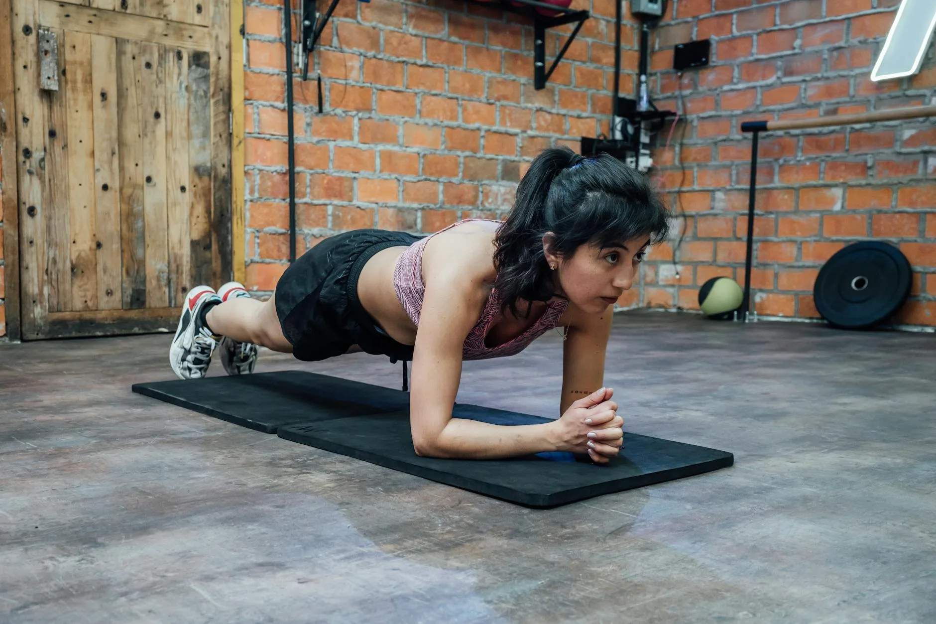 Woman holding a forearm plank on an exercise mat