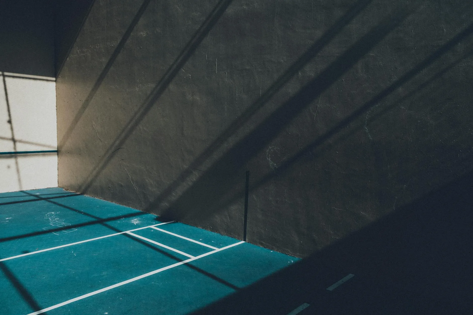 Indoor padel court with glass walls and blue floor