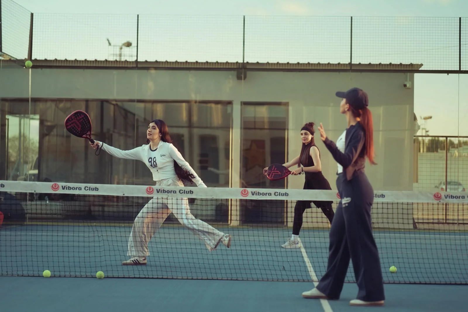 Players enjoying a padel game on an outdoor court at a UK padel club