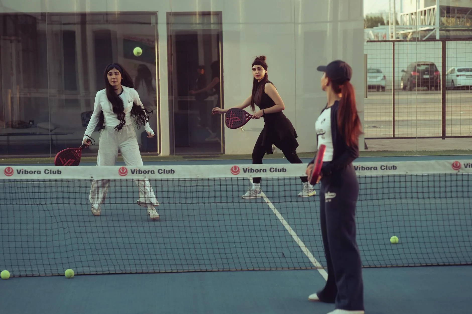 Four padel players using solid-face rackets during a match