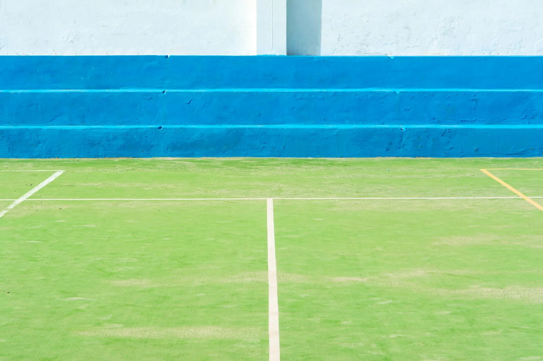Empty padel court with blue turf and glass walls ready for play