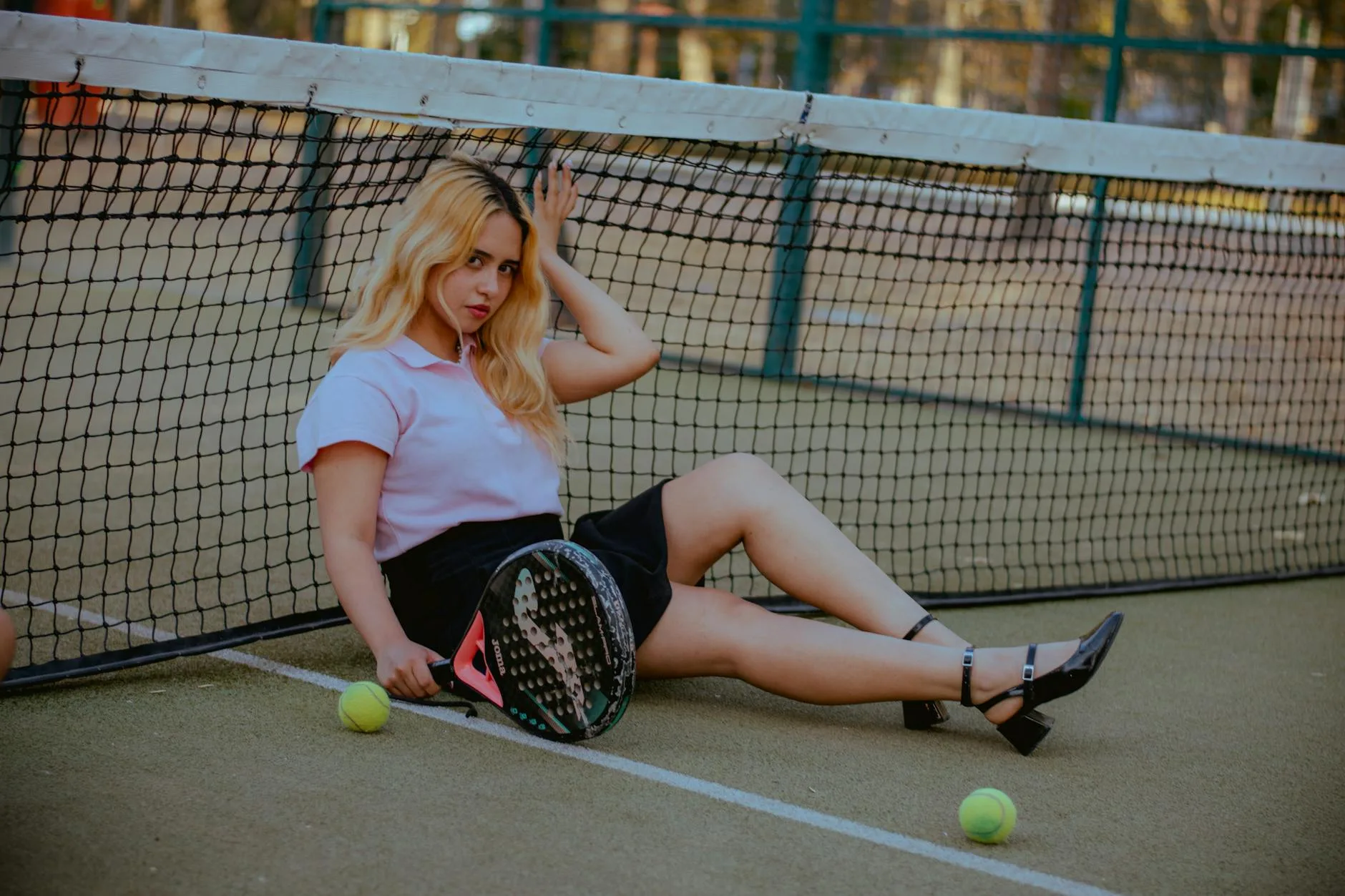 Padel player on court with racket and balls