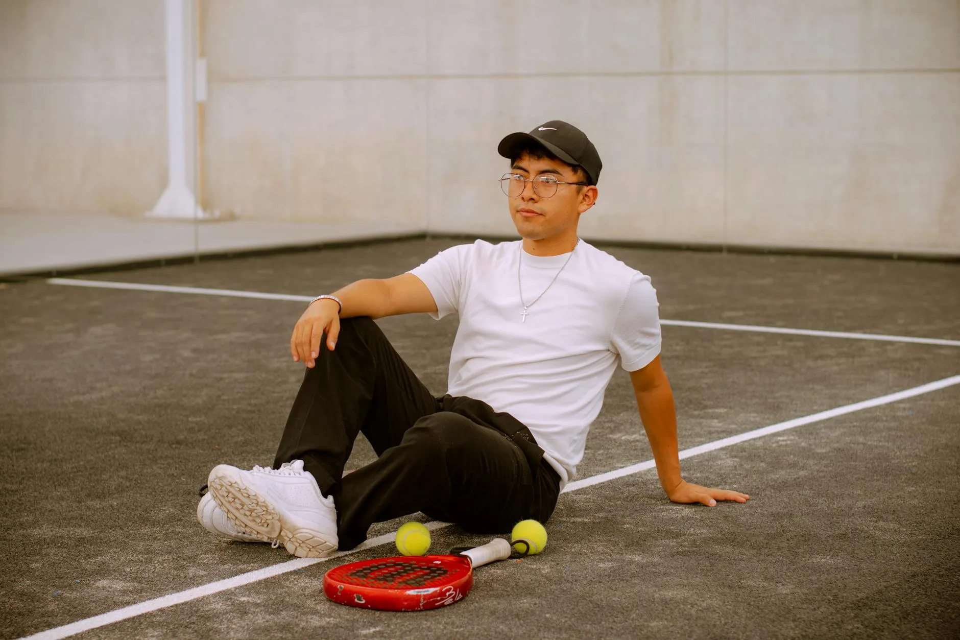 Padel player at the net on a glass-walled padel court