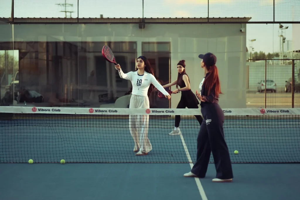 Players on a padel court with glass walls during a match