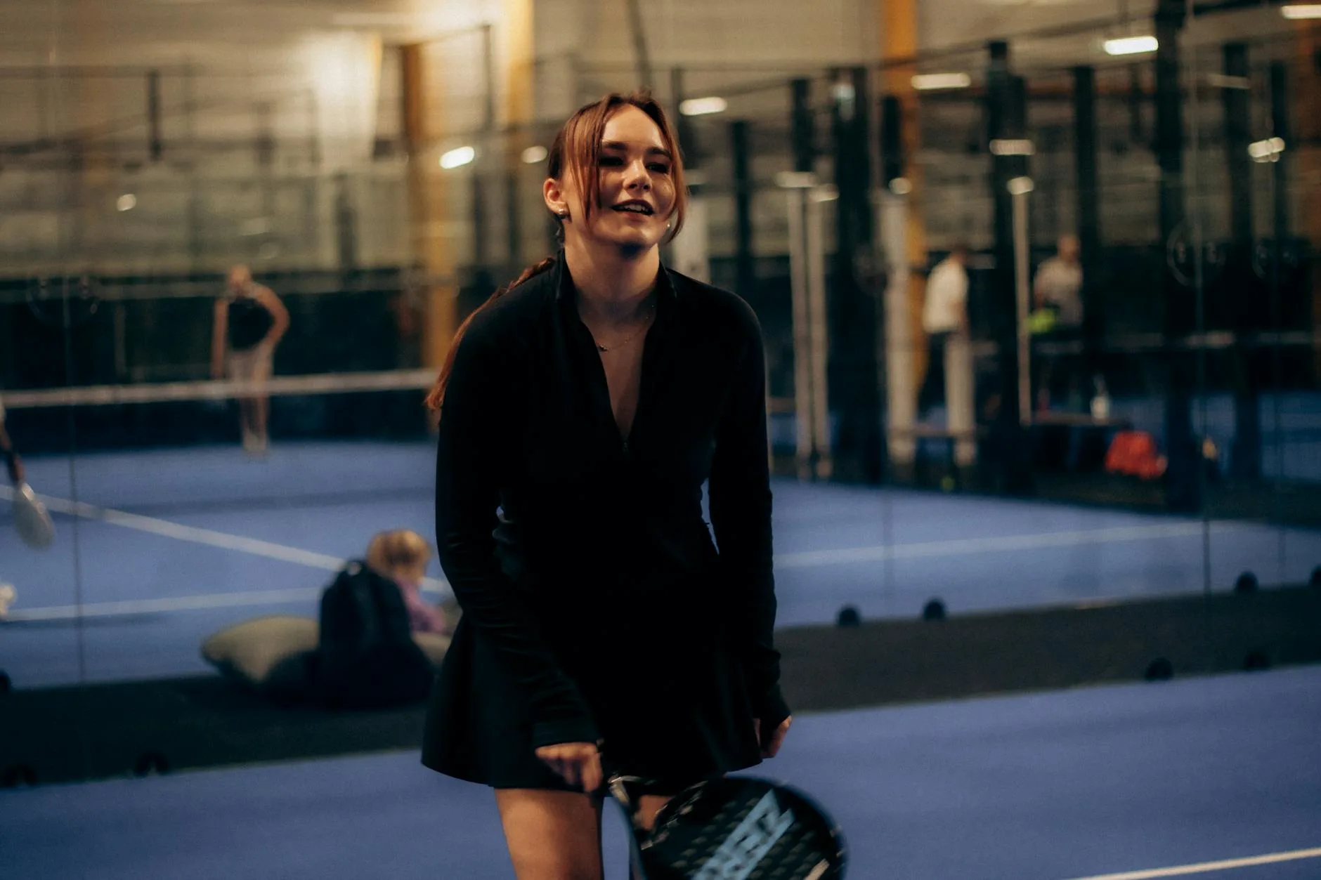 Players preparing for an indoor padel tennis match on court