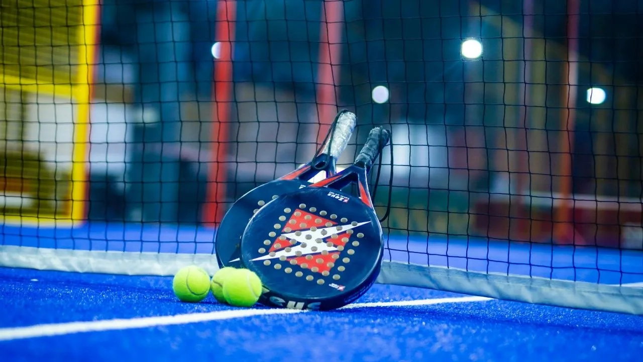 Padel racket and balls on a blue padel court