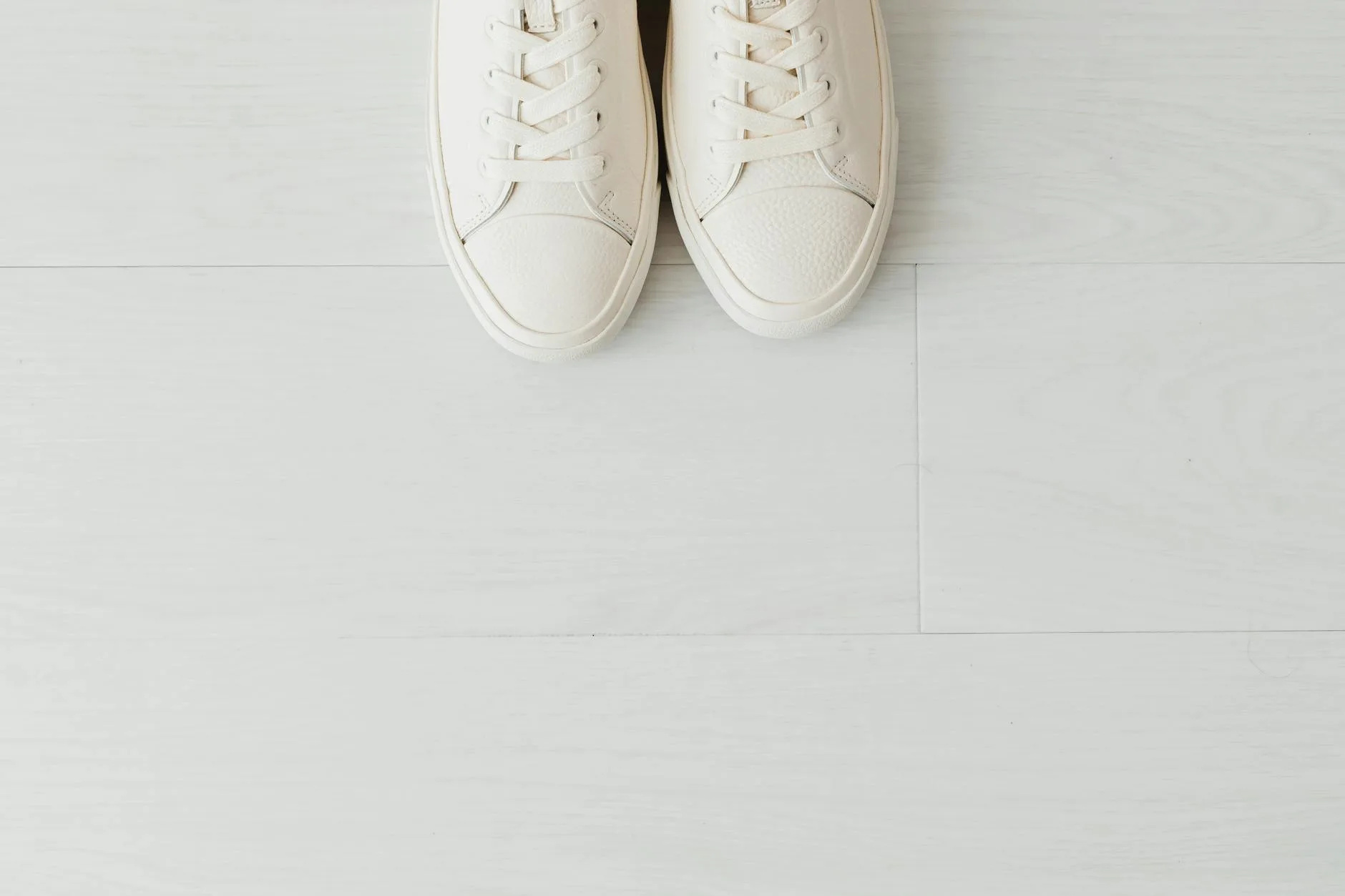Pair of white athletic court shoes on a clean surface