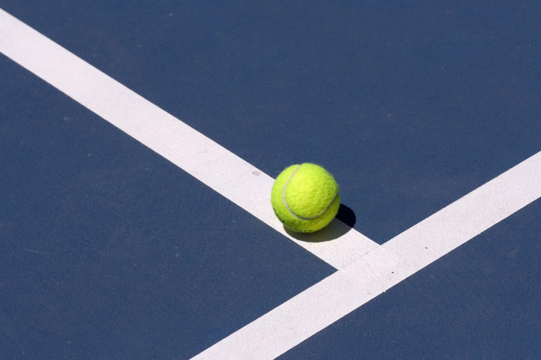 Yellow padel ball on blue court for serve practice